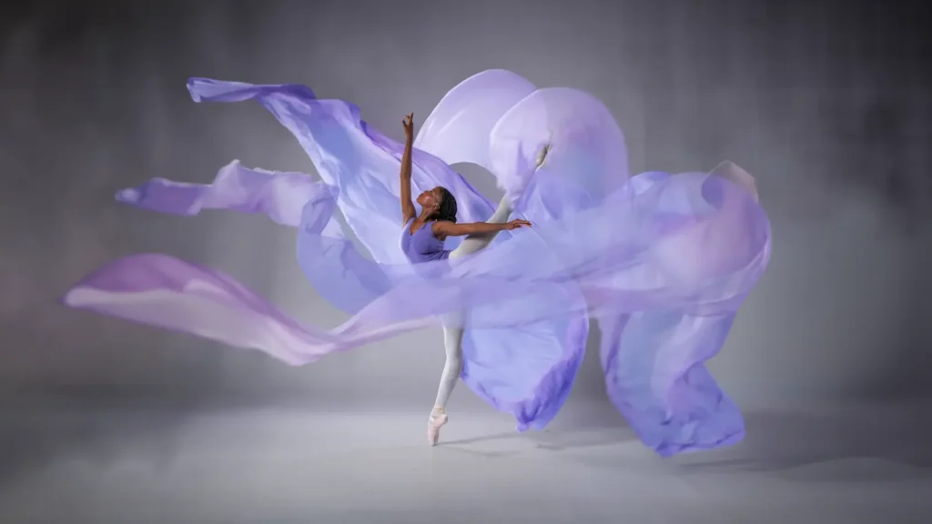 Female dancer in an elegant ballet pose with flowing purple fabric, representing ballet classes in Johannesburg.